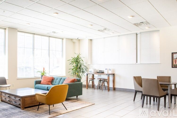 A living room with a sofa, chairs, and a dining table.