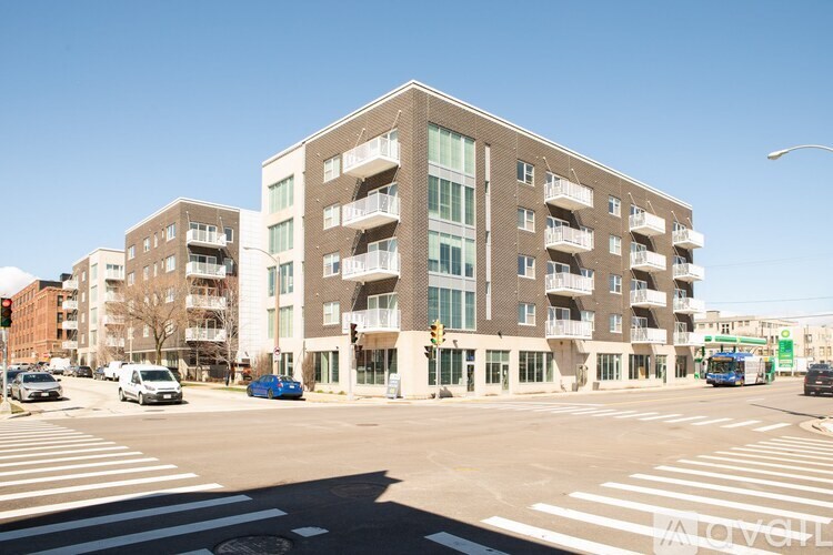 A large apartment building with a parking lot in front of it.