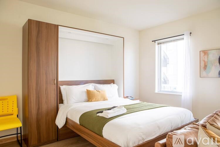 A bedroom with a large bed and a yellow chair.