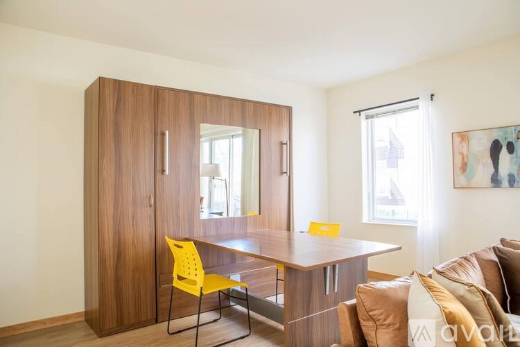 A yellow chair sits in front of a wooden table.