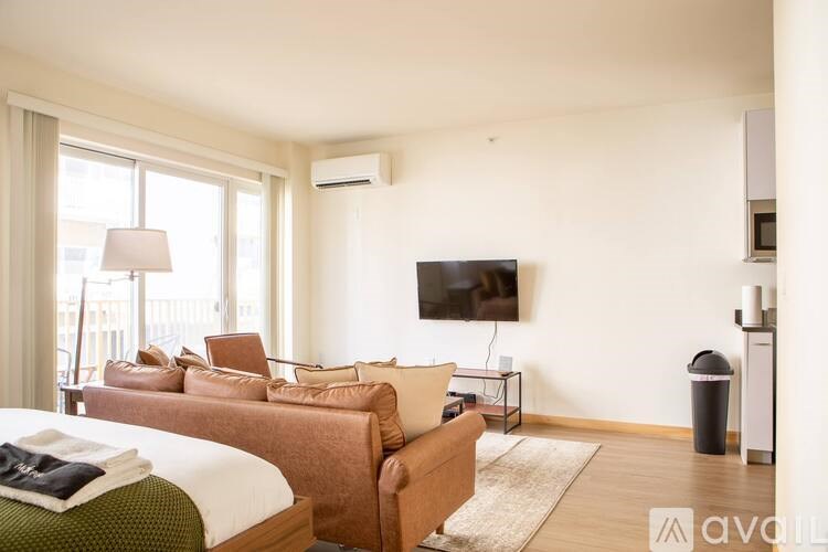 A living room with a couch, a bed, and a television.