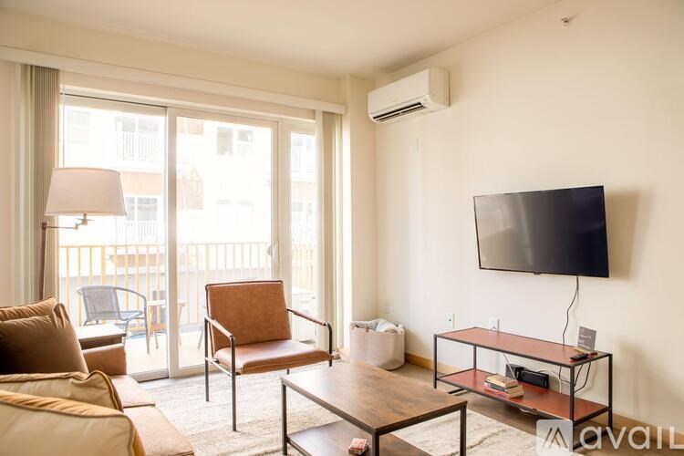A living room with a flat screen TV mounted on the wall.