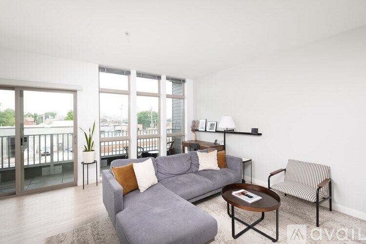 A living room with a grey couch, a striped armchair, and a coffee table.