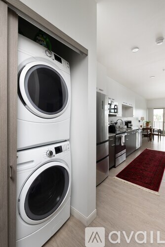 A white washing machine and dryer in a modern kitchen.
