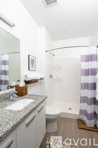 A bathroom with a toilet, sink, and shower.