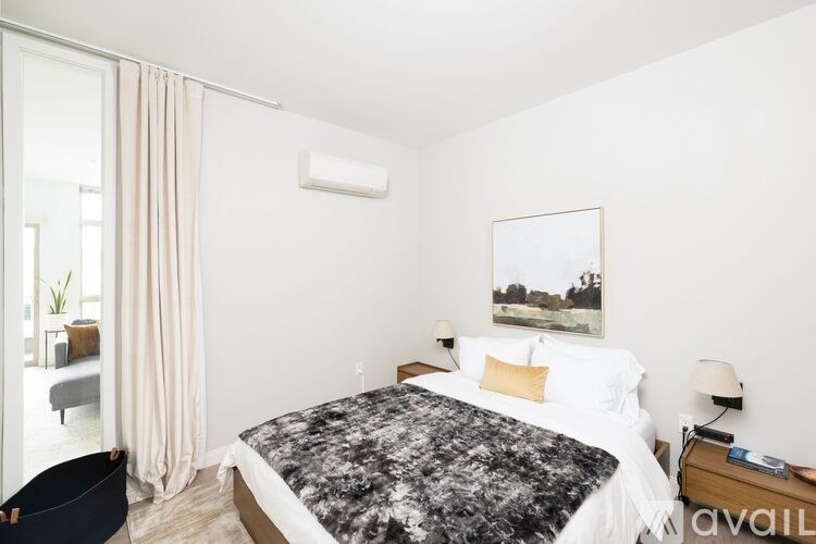 A bedroom with a large bed and a painting on the wall.