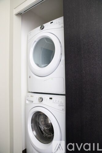 Two white washing machines in a small space.