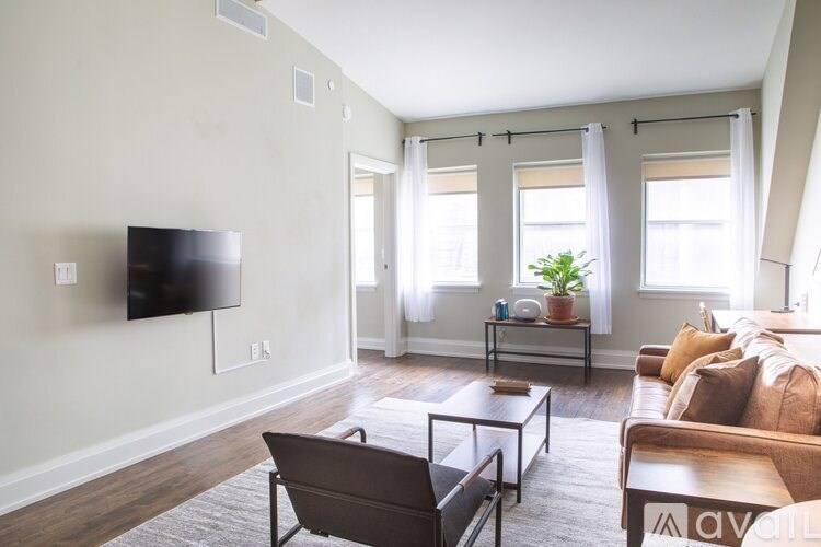 A living room with a flat screen TV mounted on the wall.