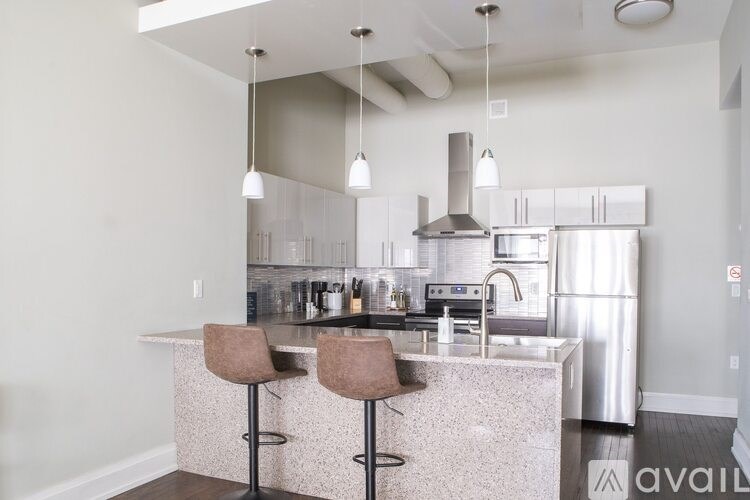 A kitchen with a marble countertop and stainless steel appliances.