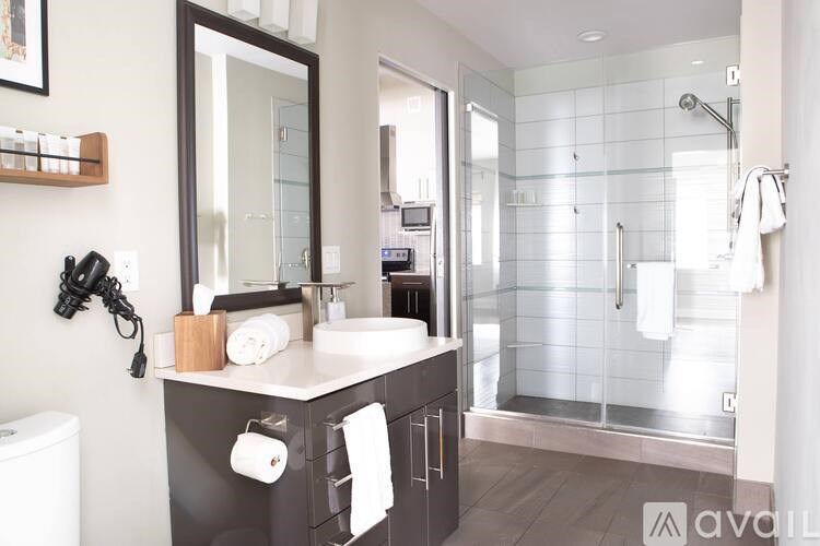 A bathroom with a sink, mirror, and shower.