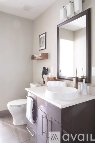 A bathroom with a white sink and a large mirror.