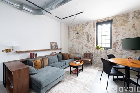 A living room with a grey couch and a wooden coffee table.