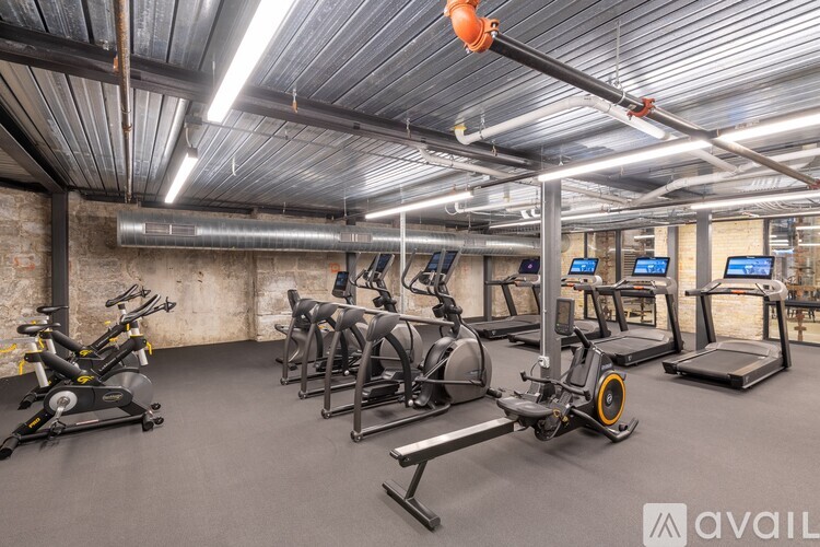 A gym with a variety of exercise equipment including treadmills, stationary bikes, and weight machines.