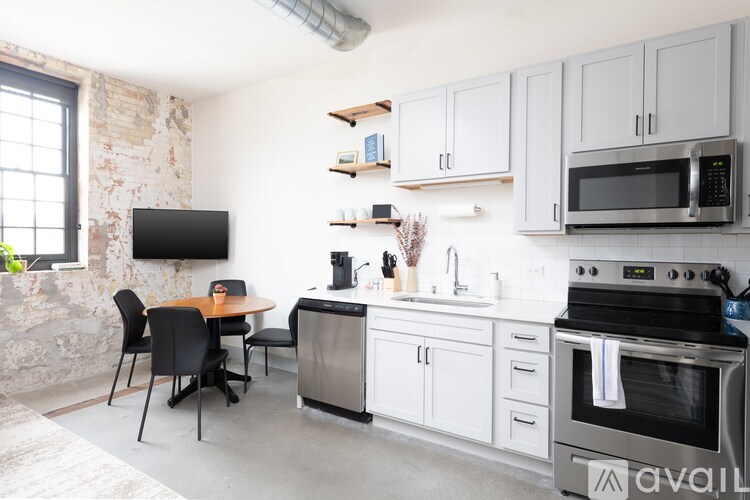 A kitchen with white cabinets and a black stove top oven.