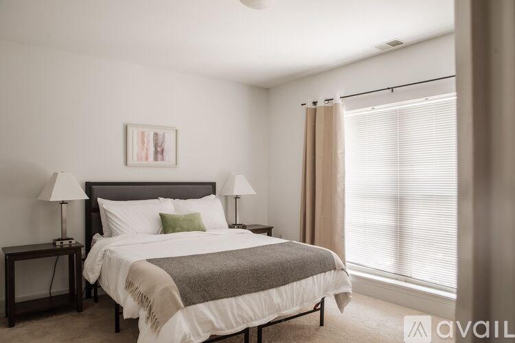 A bedroom with a large bed and a painting on the wall.