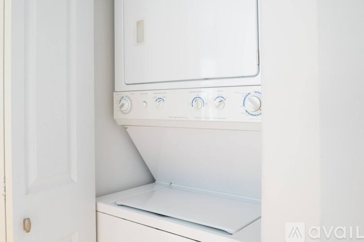 A white oven with blue knobs is installed in a kitchen.