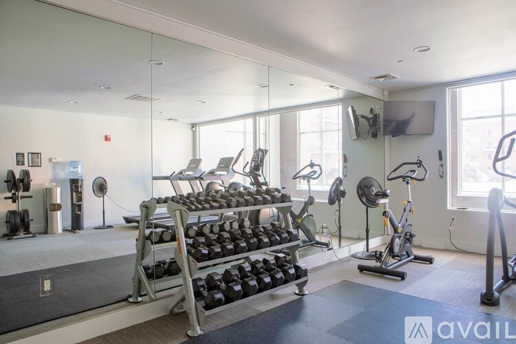 A gym with a variety of equipment including weights, treadmills, and exercise bikes.