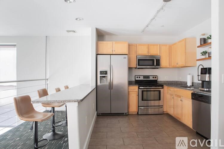 A kitchen with a refrigerator, oven, and microwave.