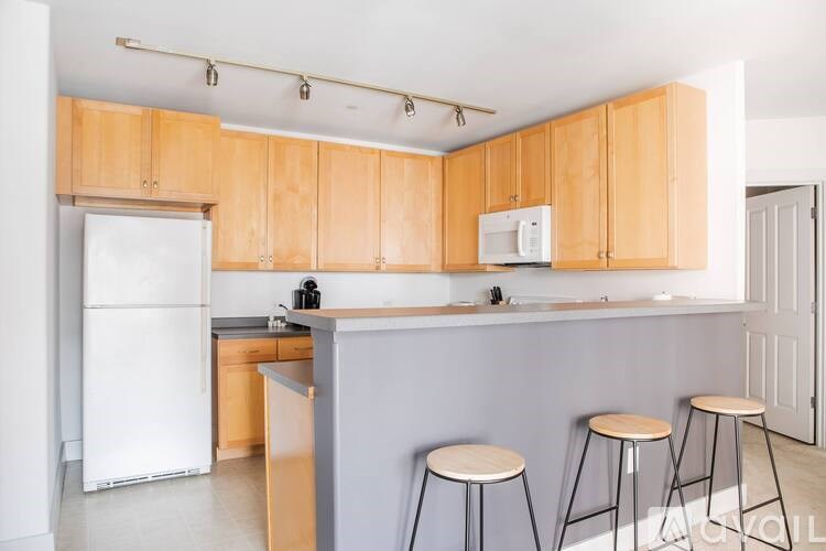 A kitchen with wooden cabinets and white appliances.
