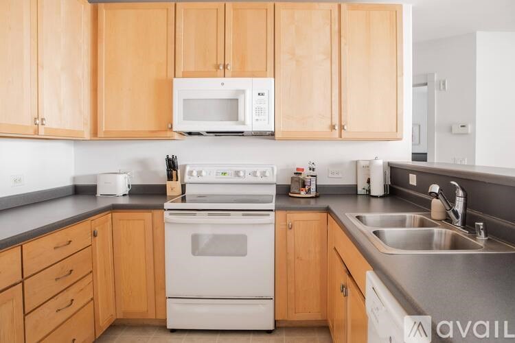 A kitchen with wooden cabinets and a white stove top oven.