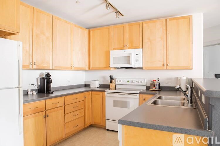A kitchen with wooden cabinets and a white fridge.