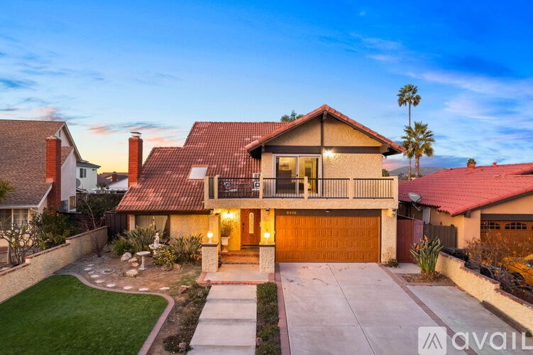 A house with a red roof and a garage door is shown.