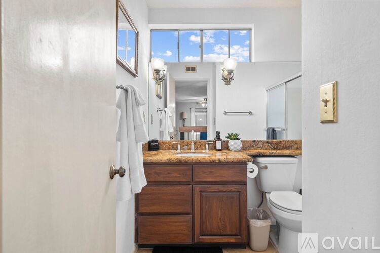 A bathroom with a wooden vanity and a large mirror.