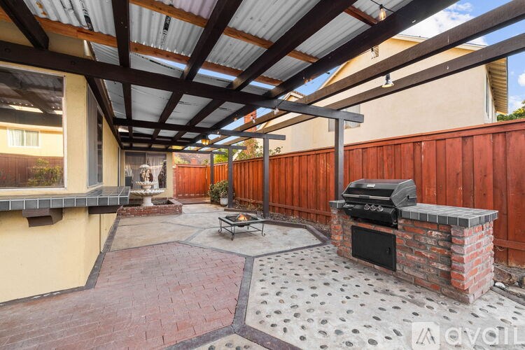 A patio with a brick fireplace and a grill.