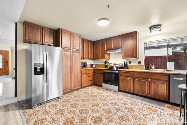 A kitchen with wooden cabinets and a patterned floor.