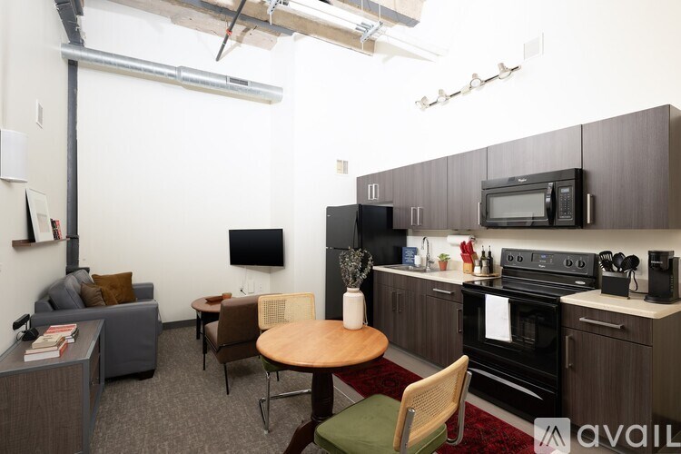A kitchen area with a table and chairs and a microwave on the counter.