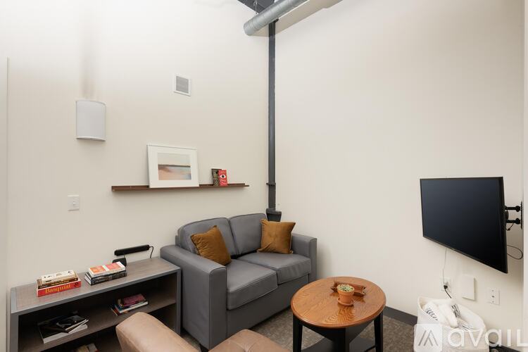 A living room with a grey couch, a coffee table, and a television.