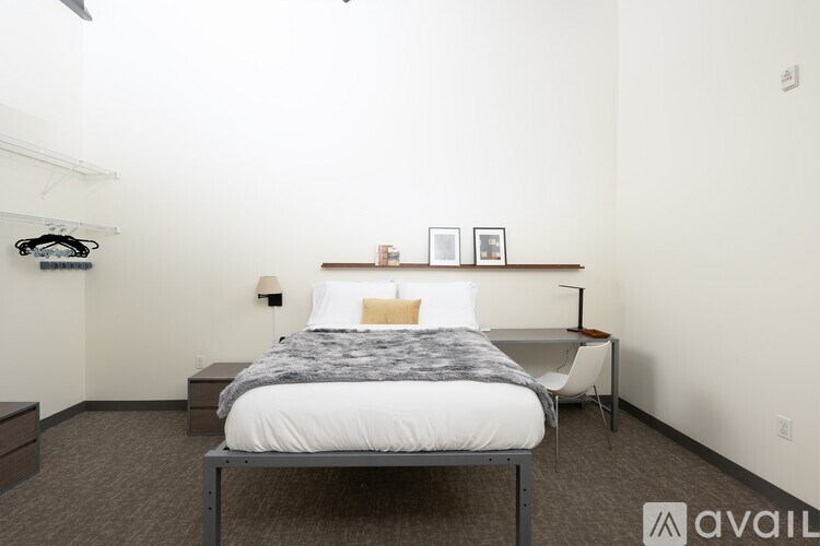 A bedroom with a bed, nightstand, and chair.