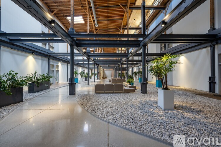 A spacious atrium with a glass ceiling and a gravel pathway.