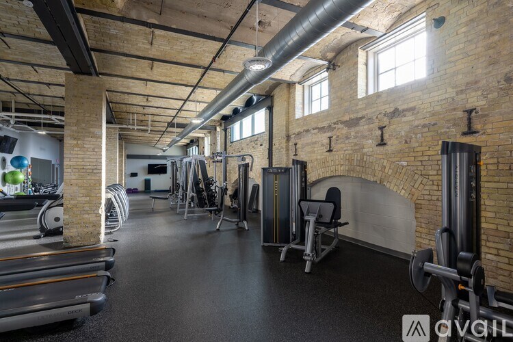 A gym with a variety of equipment including weights and cardio machines.