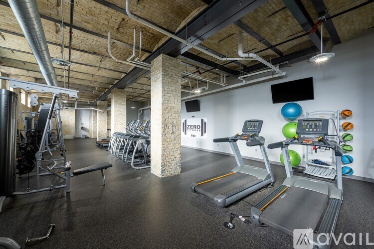 A gym with treadmills, exercise bikes, and weights.