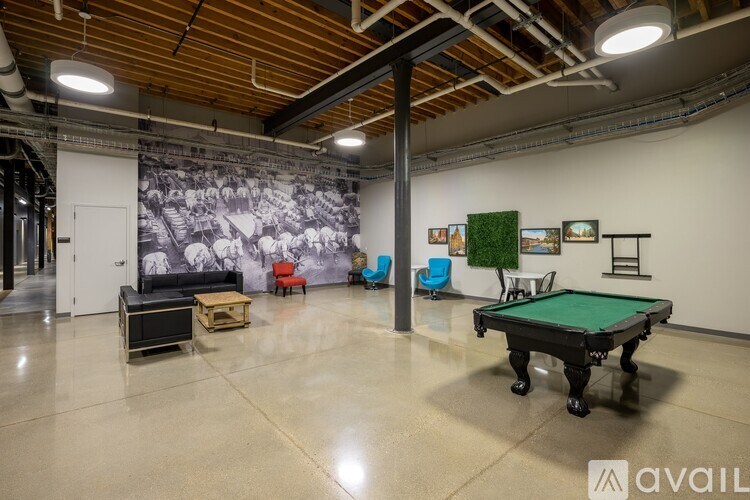 A room with a pool table and a mural on the wall.
