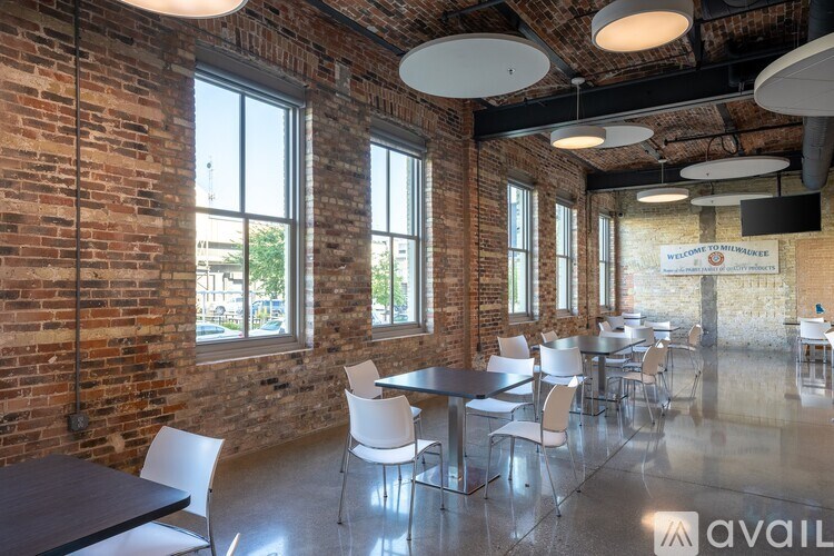 A room with tables and chairs and a sign on the wall.