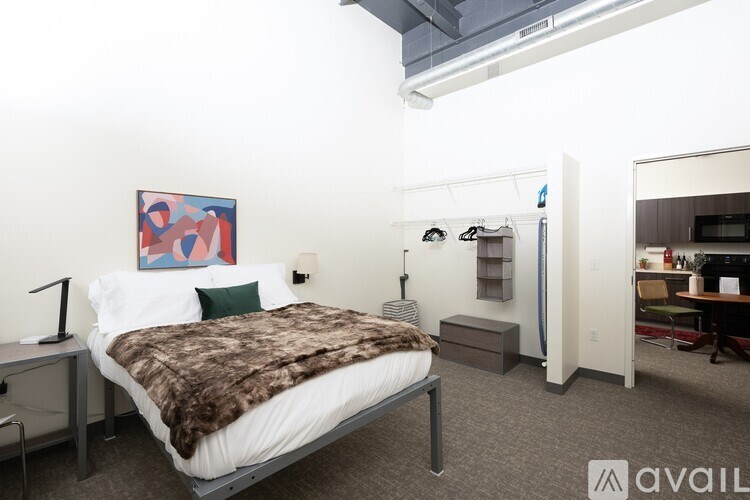 A bedroom with a bed, desk, and chair.