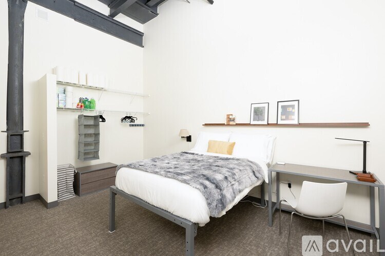 A bedroom with a bed, desk, and chair.