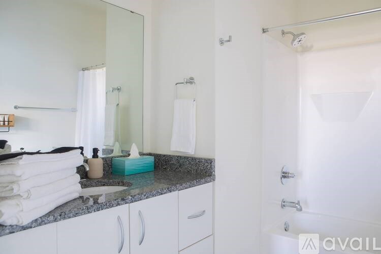A bathroom with a sink, mirror, and towel rack.