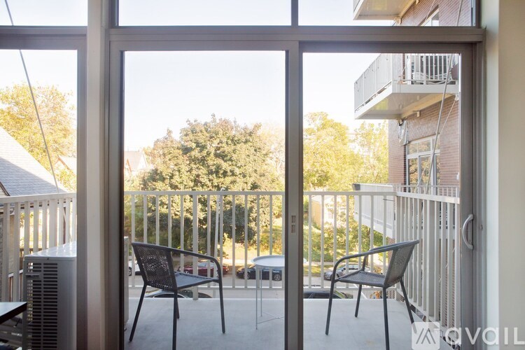 A patio with two chairs and a table is visible through a glass door.