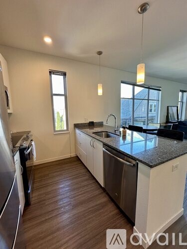 A kitchen with white cabinets and a black countertop.