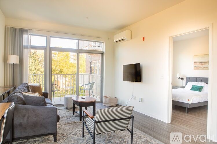 A living room with a couch, chair, and television.
