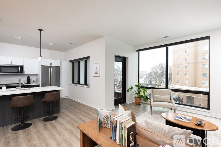A modern living room with a bar area and a view of a building outside the window.