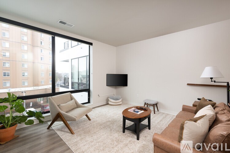 A living room with a couch, chair, and television.