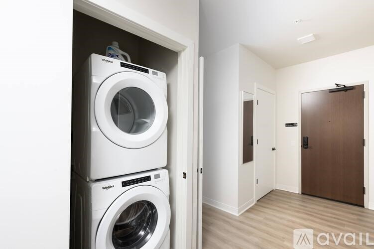A stack of two white front loading washing machines in a small laundry room.