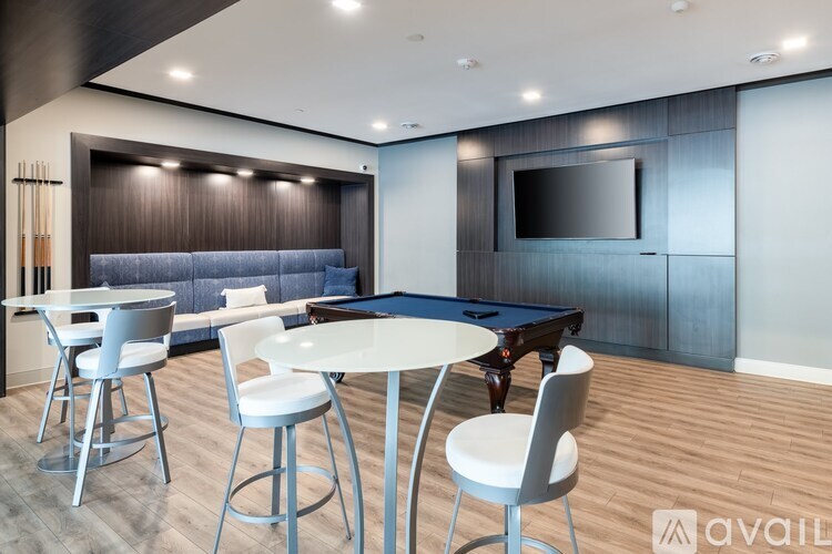 A modern living room with a pool table and a television.