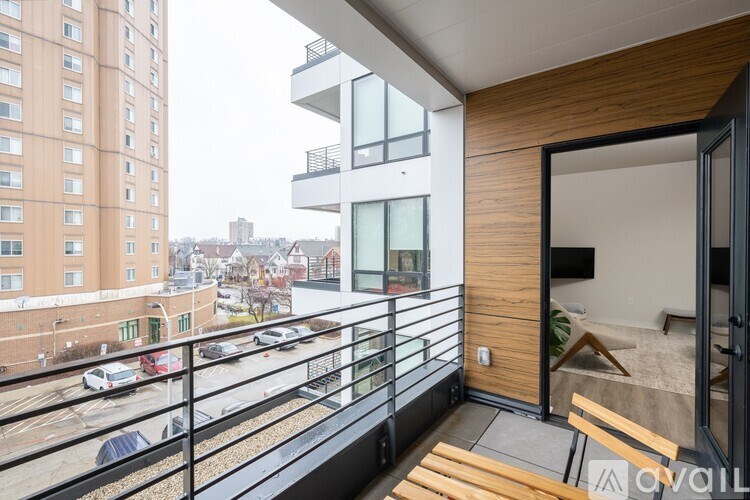 A balcony with a view of a parking lot and buildings.