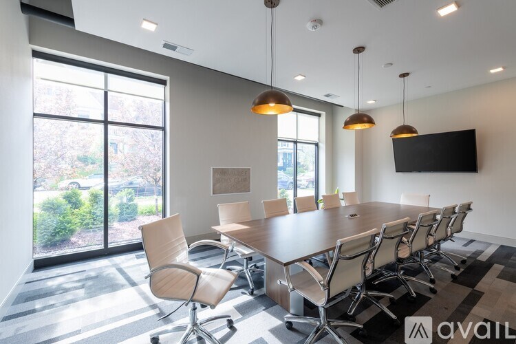A conference room with a long table and chairs, a television, and large windows.