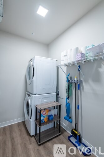 A small laundry room with a washer and dryer stacked on top of each other.